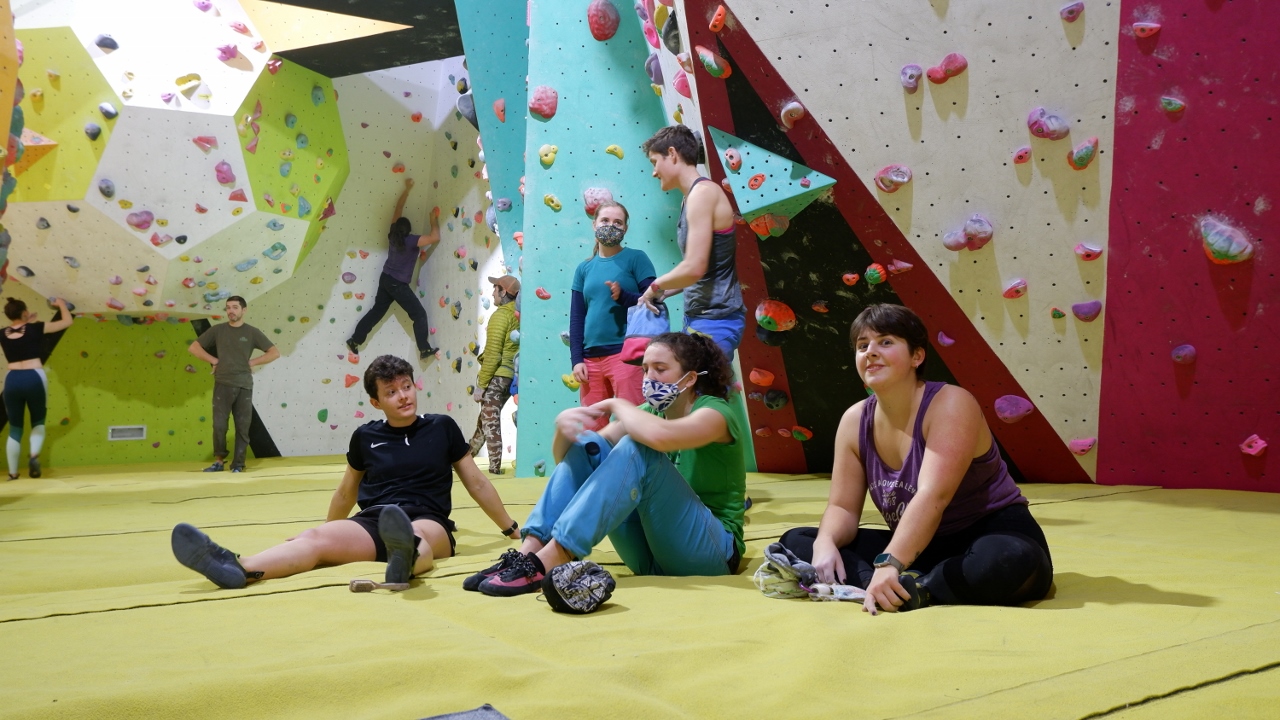 Climbers Sat on a Bouldering Mat in a Bouldering Wall